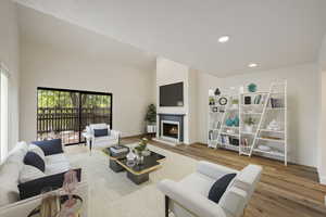 Living room with a towering ceiling and light hardwood / wood-style flooring