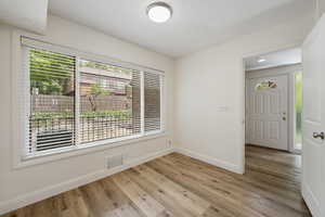 Empty room featuring a wealth of natural light and light wood-type flooring