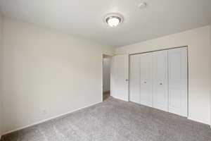 Unfurnished bedroom with a closet and carpet floors