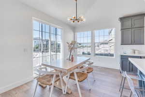 Dining space featuring an inviting chandelier, plenty of natural light, and light hardwood / wood-style floors