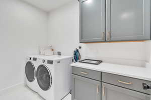 Clothes washing area with separate washer and dryer, washer hookup, and cabinets