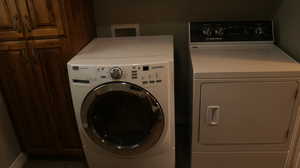 Clothes washing area with washing machine and clothes dryer, washer hookup, and cabinets