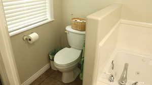 Bathroom featuring tile flooring, toilet, and a bathtub