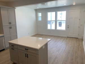 Kitchen with dishwasher, a center island, gray cabinetry, and light hardwood / wood-style floors