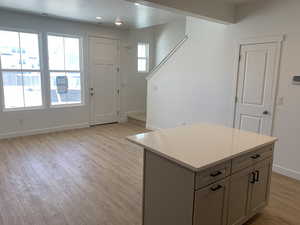 Interior space with gray cabinetry, plenty of natural light, a center island, and light wood-type flooring