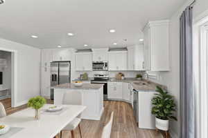 Kitchen featuring light wood-type flooring, a kitchen island, sink, light stone countertops, and appliances with stainless steel finishes AI generated