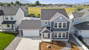 View of front of home with a front lawn, a garage, and a mountain view