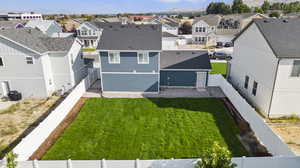 Rear view of house featuring a lawn and central AC