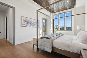 Bedroom featuring wood finished floors, multiple windows, wooden ceiling, recessed lighting, and baseboards