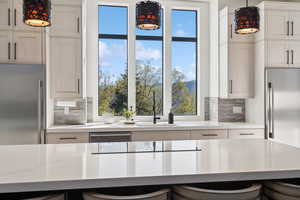 Kitchen featuring high end fridge, tasteful backsplash, and a sink