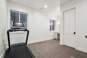 Exercise area featuring carpet and baseboards