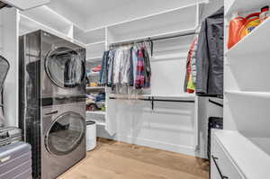 Laundry room featuring light hardwood / wood-style floors and stacked washing maching and dryer