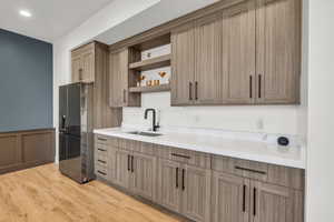 Kitchen featuring light hardwood / wood-style floors, sink, and stainless steel fridge