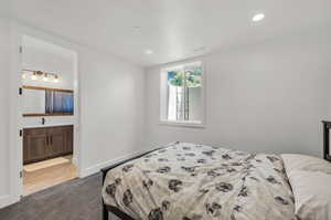 Carpeted bedroom featuring ensuite bath