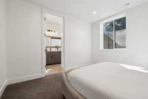 Bedroom with carpet flooring, recessed lighting, baseboards, and ensuite bathroom