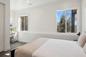Carpeted bedroom featuring multiple windows and baseboards