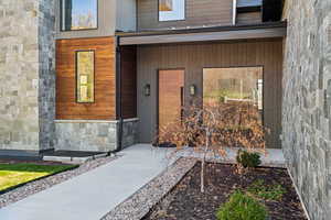 Entrance to property featuring stone siding