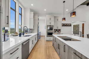 Kitchen featuring a wealth of natural light, white cabinets, light hardwood / wood-style flooring, and stainless steel appliances