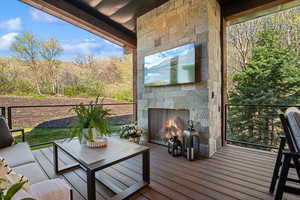 Wooden deck with an outdoor living space with a fireplace