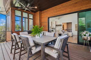 Wooden terrace featuring ceiling fan and outdoor dining area