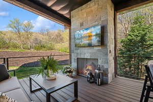 Wooden terrace with an outdoor stone fireplace