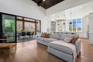 Living room featuring hardwood / wood-style floors, beam ceiling, high vaulted ceiling, wooden ceiling, and recessed lighting