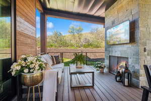 Deck featuring an outdoor living space with a fireplace