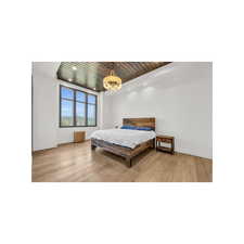 Bedroom with a notable chandelier, wood ceiling, and light wood-type flooring