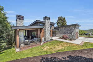 Rear view of house with a patio area and a lawn