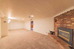 Basement featuring carpet and a brick fireplace