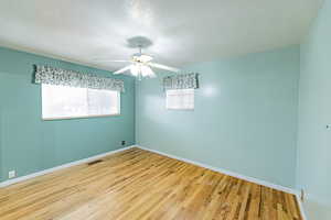 Empty room with ceiling fan and light hardwood / wood-style floors