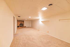 Basement with carpet floors and a fireplace