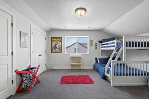 Carpeted bedroom with vaulted ceiling