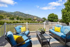 Deck featuring outdoor lounge area, a yard, and a mountain view