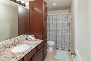 Bathroom featuring tile floors, vanity, and toilet