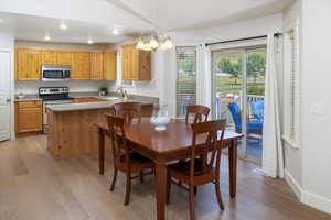 Dining room with light hardwood floors, sink, and a notable chandelier