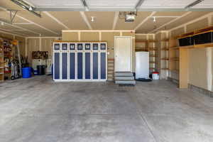 Garage featuring a garage door opener & built in shelving with locker storage