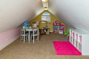 Recreation room with vaulted ceiling and carpet