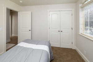 Bedroom with a closet and dark colored carpet