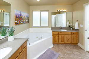 Master Bathroom featuring tile floors, a bath to relax in, and vanity