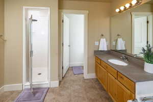 Master Bathroom featuring vanity, tile floors, and a full floor to ceiling cultured marble shower with door