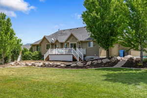 Back of property featuring a wooden deck and a yard