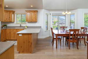 Dining room with sink, a chandelier, and light wood flooring