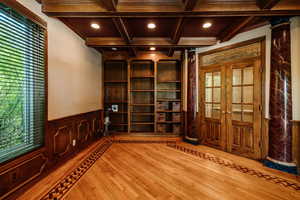 Office: Interior space featuring coffered ceiling, light hardwood / wood-style flooring, wood trimmed ceiling, and french doors from Foyer.