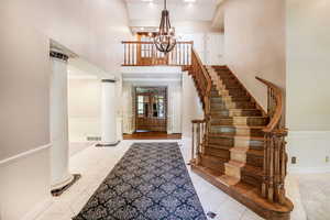 Marble foyer with grand chandelier, a towering ceiling, and ornate columns. (Priced adjusted for new carpet runner on staircase.)