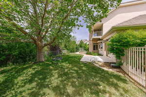 View of backyard with a patio area, a fire pit, and a balcony above, off the Primary Suite upstairs.