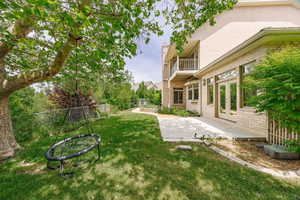 View of yard with a balcony and first patio of the Kitchen.