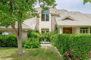 View of front facade with a front yard and side court statue.  Makes a statement and beautifully set outside the dining room window.