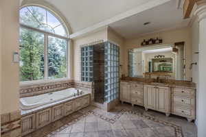 Bathroom with tile flooring, shower with separate bathtub, a wealth of natural light, and vanities on each side for plenty of SPACE!