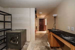 Interior space in the basement, featuring sink and  textured ceiling.  Great for the hobbyist.  (Safe has been there from past owners; stays but owner doesn't know the combo.)